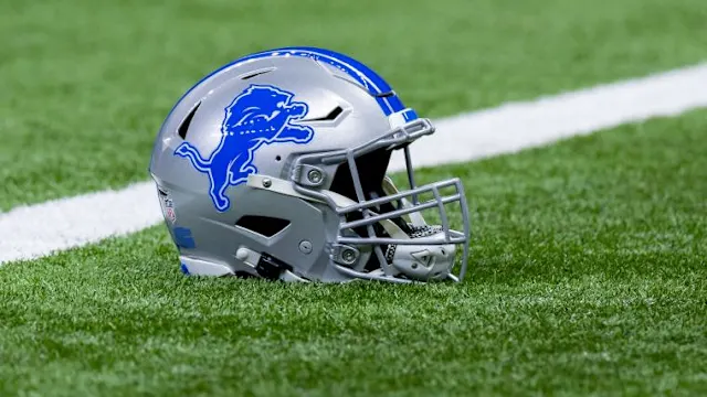 A player's Lions helmet laying on the grass.